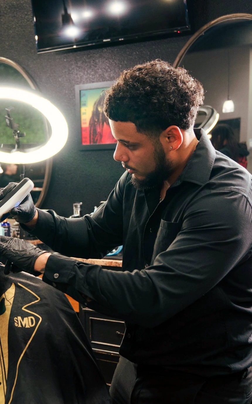 Jasiah lining up a skin fade under the ring light